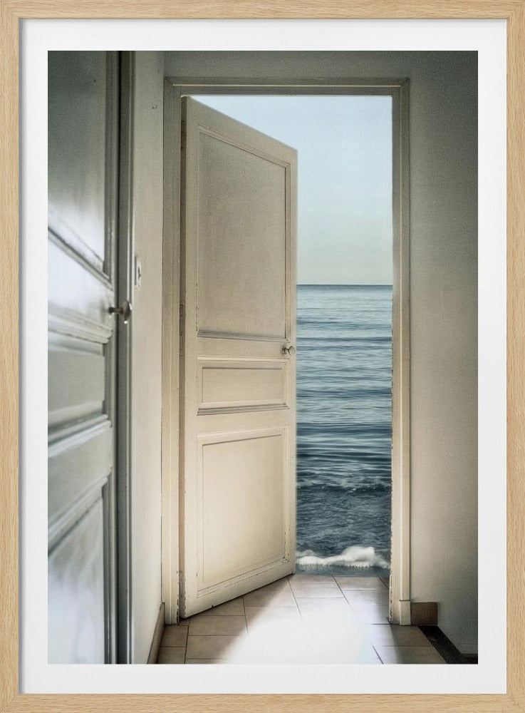 A surreal photograph showing a white interior door swung open, revealing not a landscape but the vast blue ocean, with waves gently washing over the tiled floor of the room. Decor