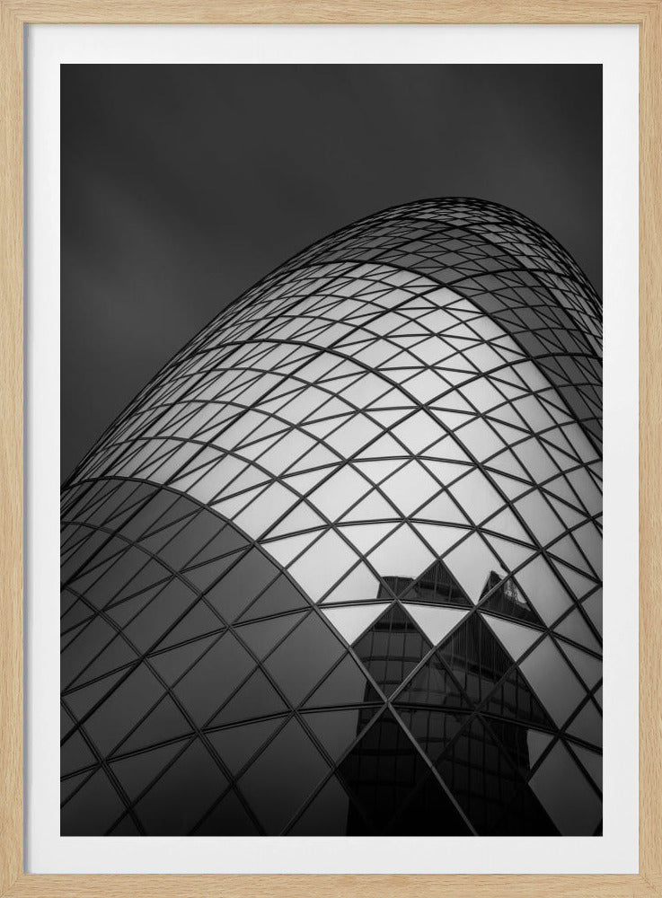 A framed, low-angle, black and white photograph of the curved, glass-paneled facade of a modern skyscraper, creating a dynamic pattern of reflective diamonds against a dark, moody sky. Artwork