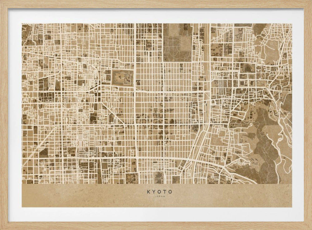 A framed, stylized map of Kyoto, Japan, in shades of brown and beige. The city streets are illustrated as a complex grid of off-white lines against a textured brown background. At the bottom, a solid beige banner contains the text 'KYOTO' and 'JAPAN' in a modern sans-serif font. The artwork is surrounded by a brushed silver frame. Artwork