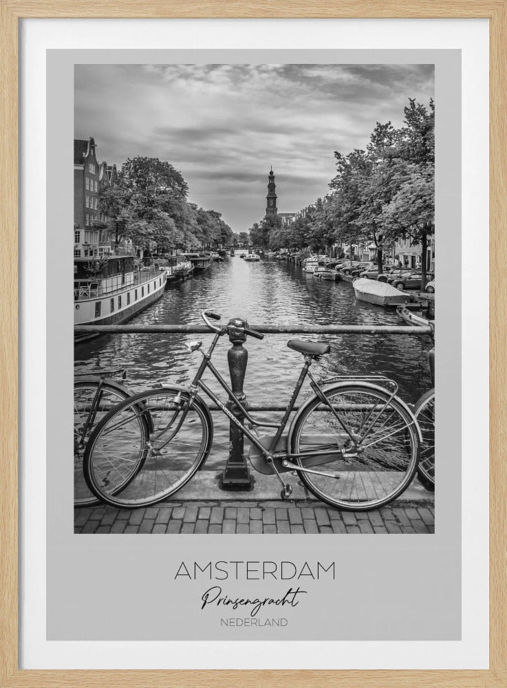 A black and white poster of the Prinsengracht canal in Amsterdam. A bicycle is parked on a bridge in the foreground, overlooking the canal lined with houseboats, trees, and traditional Dutch buildings. The Westerkerk church tower is visible in the distance. The poster has a white border with the words 'AMSTERDAM', 'Prinsengracht', and 'NEDERLAND' at the bottom. Poster