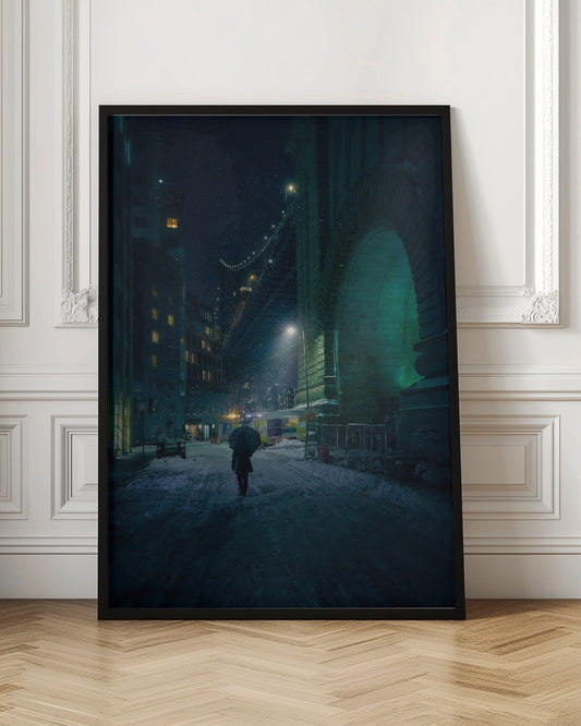 A lone person holding an umbrella walks down a snow-covered street at night, dwarfed by the massive, green-lit stone archway of the Brooklyn Bridge as snow falls around them. Print