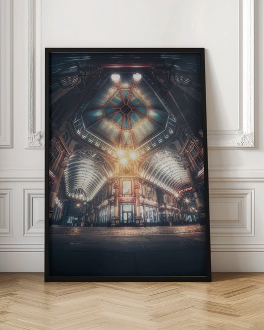 A dramatic, low-angle, wide shot of an empty Leadenhall Market at night. The ornate, domed ceiling is illuminated in blue and gold by bright, warm lights, which also cast a glow on the cobblestone floor and detailed Victorian storefronts. Wall Art