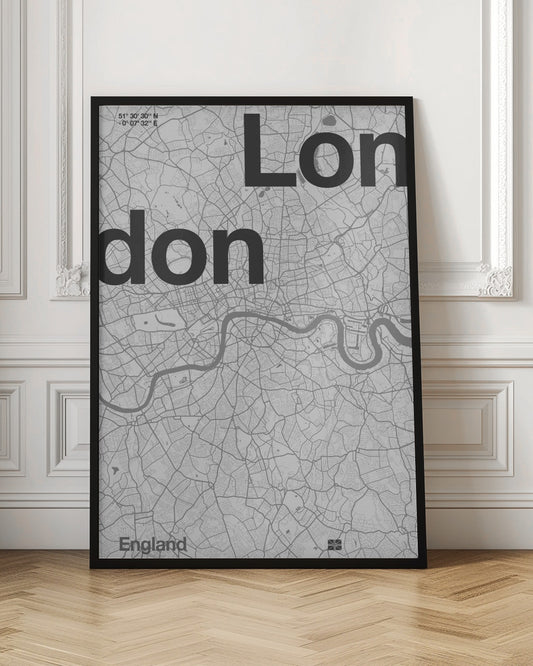 A framed, minimalist black and white street map of London. The word 'London' is split into two lines, 'Lon' and 'don', in large, bold black font overlaid on the light grey map. The River Thames snakes through the center in a darker grey, matching the intricate street grid. Coordinates are in the top left corner, and 'England' is in the bottom left. Decor