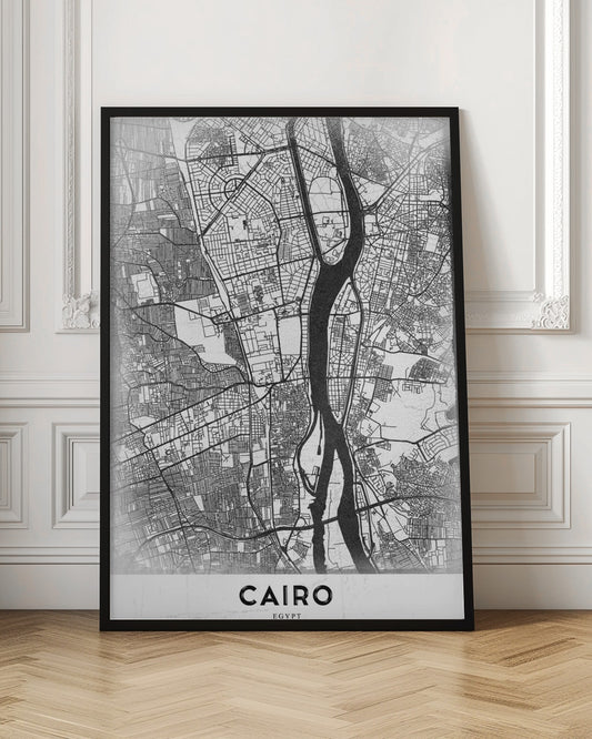 A minimalist black and white framed poster of a street map of Cairo. The Nile River flows vertically through the center of the detailed city grid. The word 'CAIRO' is printed in a bold, black, sans-serif font at the bottom. Decor