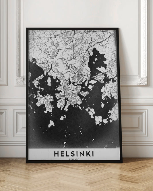 A modern black and white map of Helsinki, Finland, presented in a black frame. The city's street grid is detailed in white lines on a textured black background representing the water, creating a high-contrast, minimalist design. The name 'HELSINKI' is printed in bold capital letters at the bottom on a white banner. Artwork