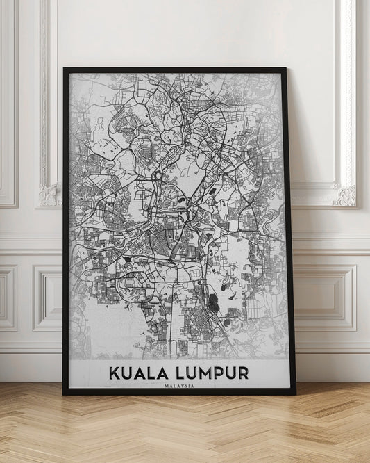 A minimalist black and white street map of Kuala Lumpur, displayed in a black frame. The map shows a detailed network of roads and city blocks on a textured white background. The name "KUALA LUMPUR" is printed in a bold, modern font at the bottom. Decor