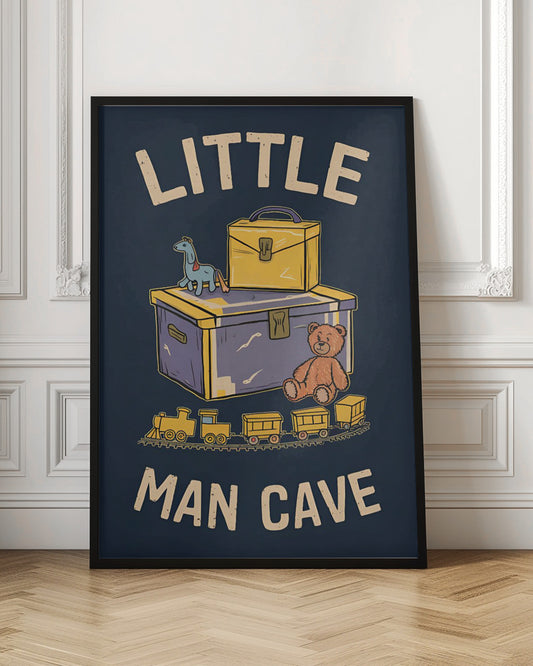 A framed vintage-style illustration with the text 'LITTLE MAN CAVE' on a dark blue background. The artwork features classic toys, including a toy chest, a teddy bear, a toy train on tracks, and a small horse on wheels. Decor