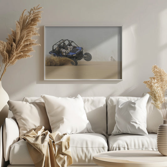 A framed action shot of a blue dune buggy with several passengers making a sharp turn in the desert, kicking up a large cloud of sand and lifting its front wheel off the ground. Wall Art