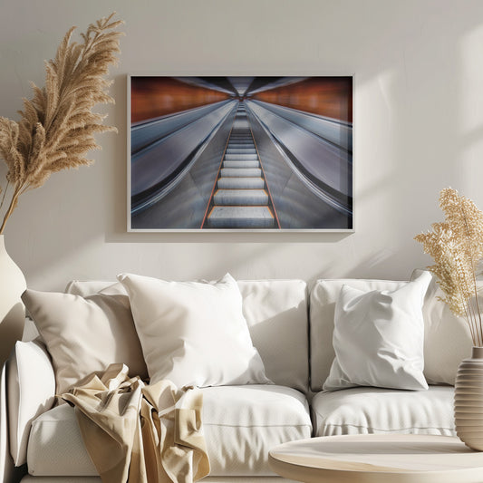 A symmetrical, low-angle photograph looking up a very long escalator, creating a strong sense of perspective towards a vanishing point. The orange walls are motion-blurred, suggesting speed, while the metallic steps in the center remain clear. Decor