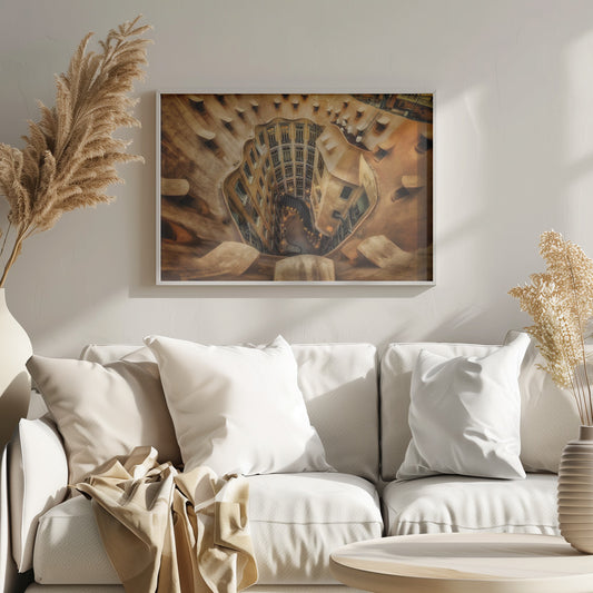 A high-angle, downward view of the inner courtyard of an architecturally unique building, likely Casa Milà by Gaudí. The warm, sandy-colored walls curve and undulate organically, surrounding the multi-story structure with its many windows. The courtyard below is lit, casting a warm glow. Decor