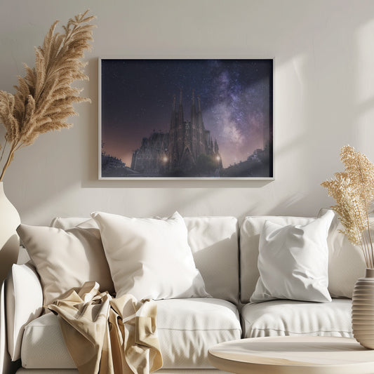 A fantastical night view of the Sagrada Familia in Barcelona, its intricate spires reaching up towards a magnificent, starry sky filled with the purple and pink hues of the Milky Way galaxy, all enclosed in a silver frame. Artwork