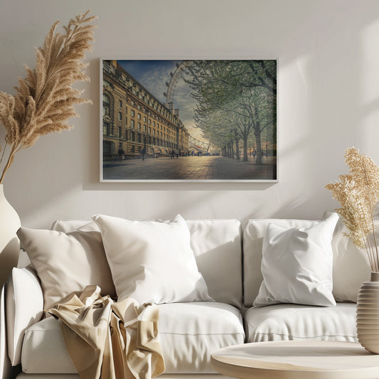 A scenic view of London's South Bank at sunset, with the London Eye visible in the background, a grand historic building on the left, and a row of white blossoming trees lining the sunlit promenade on the right. Wall Art