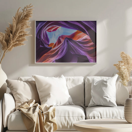 A low-angle photograph looking up from inside a vibrant slot canyon. The smooth, flowing sandstone walls are colored in rich shades of purple, red, and orange, curving around an opening that reveals a bright blue sky with wispy clouds. The image is presented within a silver-colored frame. Wall Art