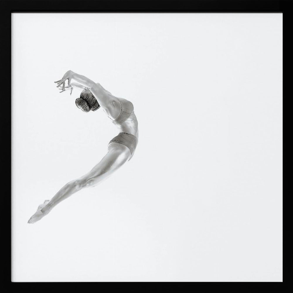 A minimalist black and white photograph of a graceful dancer frozen in mid-air, her body arched backward in an elegant C-shape against a stark white background. The artwork is presented in a light wood frame. Decor
