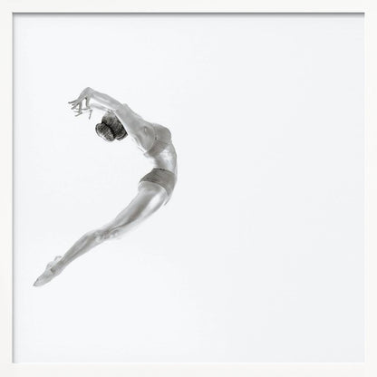A minimalist black and white photograph of a graceful dancer frozen in mid-air, her body arched backward in an elegant C-shape against a stark white background. The artwork is presented in a light wood frame. Decor