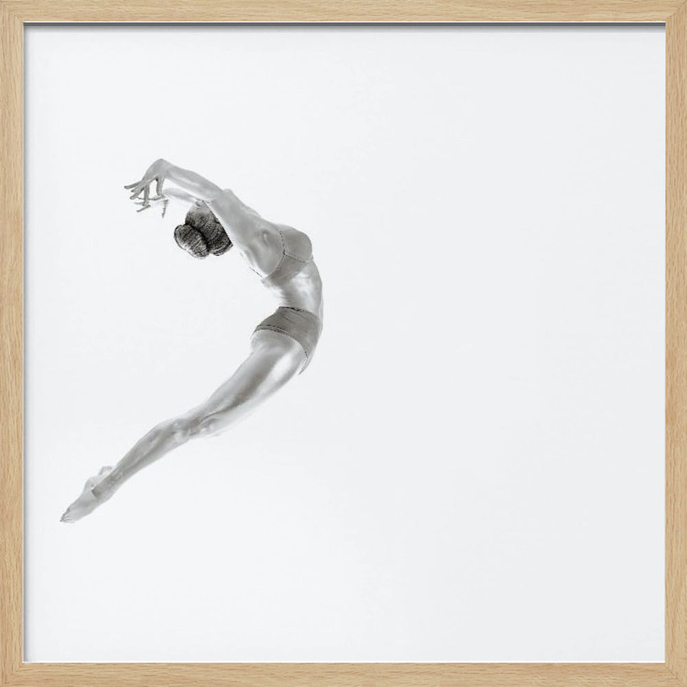 A minimalist black and white photograph of a graceful dancer frozen in mid-air, her body arched backward in an elegant C-shape against a stark white background. The artwork is presented in a light wood frame. Decor