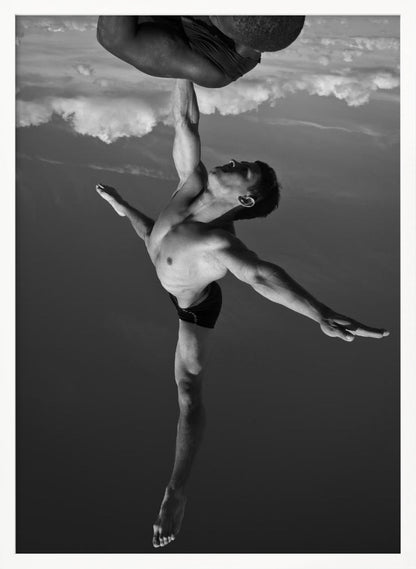 A surreal black and white photograph of two male acrobats. One man, in a graceful dance-like pose balancing on one leg, holds another man aloft with a single outstretched arm. The man being held is upside down against a backdrop of clouds, creating a gravity-defying and artistic illusion. Print