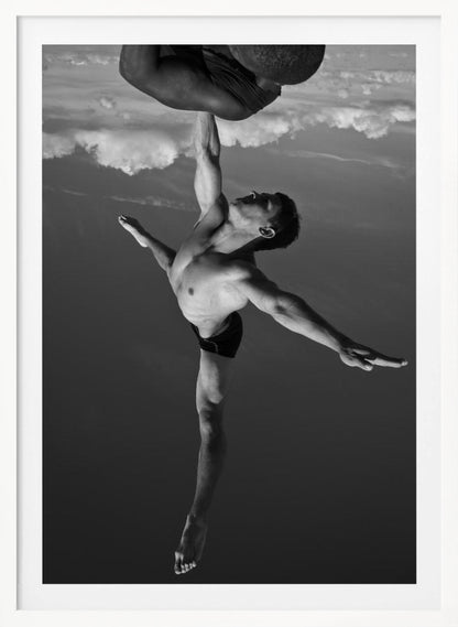 A surreal black and white photograph of two male acrobats. One man, in a graceful dance-like pose balancing on one leg, holds another man aloft with a single outstretched arm. The man being held is upside down against a backdrop of clouds, creating a gravity-defying and artistic illusion. Print