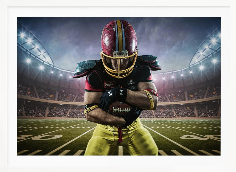 A framed poster of a determined football player in a red and yellow uniform standing on a field in a packed stadium. He is holding a football close to his chest with his head bowed, under bright stadium lights. Decor