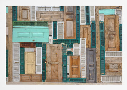 A framed art piece featuring a chaotic collage of various old, weathered wooden doors and window shutters arranged in a dense patchwork, showcasing a rustic texture and colors like natural wood, teal, green, and distressed white. Wall Art