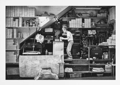 A vintage art print depicting a small, old-fashioned printing shop interior, showcasing antique machinery and a nostalgic atmosphere. Artwork