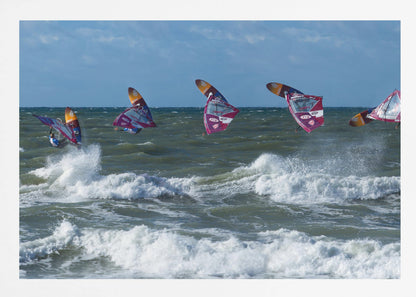 A composite, silver-framed photograph capturing the four stages of a windsurfer's impressive jump over choppy, white-capped ocean waves under a partly cloudy blue sky. Print
