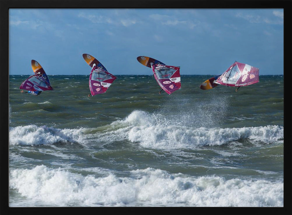 A composite, silver-framed photograph capturing the four stages of a windsurfer's impressive jump over choppy, white-capped ocean waves under a partly cloudy blue sky. Print