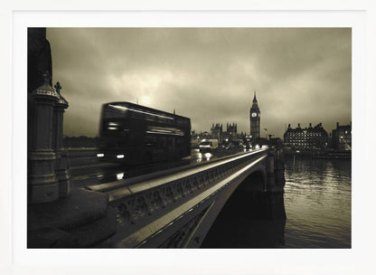 A framed, sepia-toned long-exposure photograph of London. A double-decker bus is shown in motion blur as it crosses Westminster Bridge. In the background, the Big Ben clock tower and the Houses of Parliament are visible against a cloudy sky, with lights reflecting on the wet road and the River Thames. Wall Art