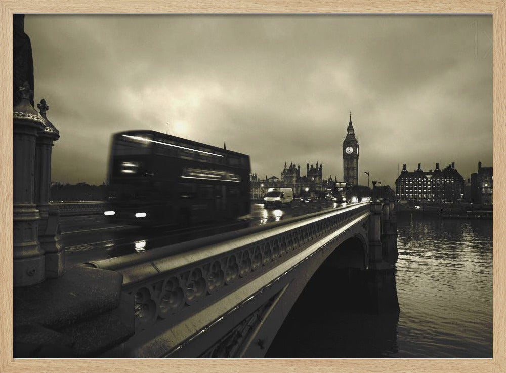 A framed, sepia-toned long-exposure photograph of London. A double-decker bus is shown in motion blur as it crosses Westminster Bridge. In the background, the Big Ben clock tower and the Houses of Parliament are visible against a cloudy sky, with lights reflecting on the wet road and the River Thames. Wall Art