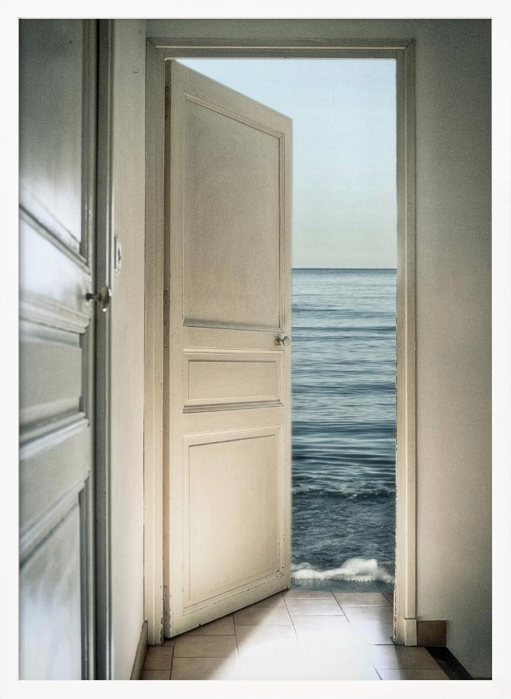 A surreal photograph showing a white interior door swung open, revealing not a landscape but the vast blue ocean, with waves gently washing over the tiled floor of the room. Decor