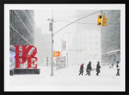 A photograph of a busy city street during a heavy snowstorm. In the foreground on the left, a large, bright red sculpture spells out the word 'HOPE', providing a stark contrast to the muted, white, and gray tones of the snowy scene. Pedestrians in winter coats are crossing the snow-covered street, and tall buildings are partially obscured by the falling snow in the background. Wall Art