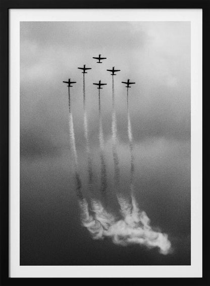 A grainy black and white photo of six airplanes flying in a V-formation against a cloudy sky. Each plane leaves a long, white smoke trail that billows at the bottom of the frame. The image is presented within a black border. Print