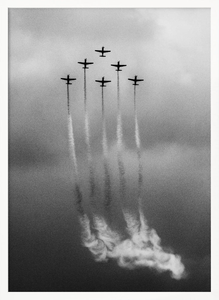 A grainy black and white photo of six airplanes flying in a V-formation against a cloudy sky. Each plane leaves a long, white smoke trail that billows at the bottom of the frame. The image is presented within a black border. Print