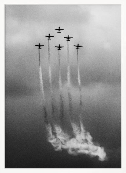 A grainy black and white photo of six airplanes flying in a V-formation against a cloudy sky. Each plane leaves a long, white smoke trail that billows at the bottom of the frame. The image is presented within a black border. Print