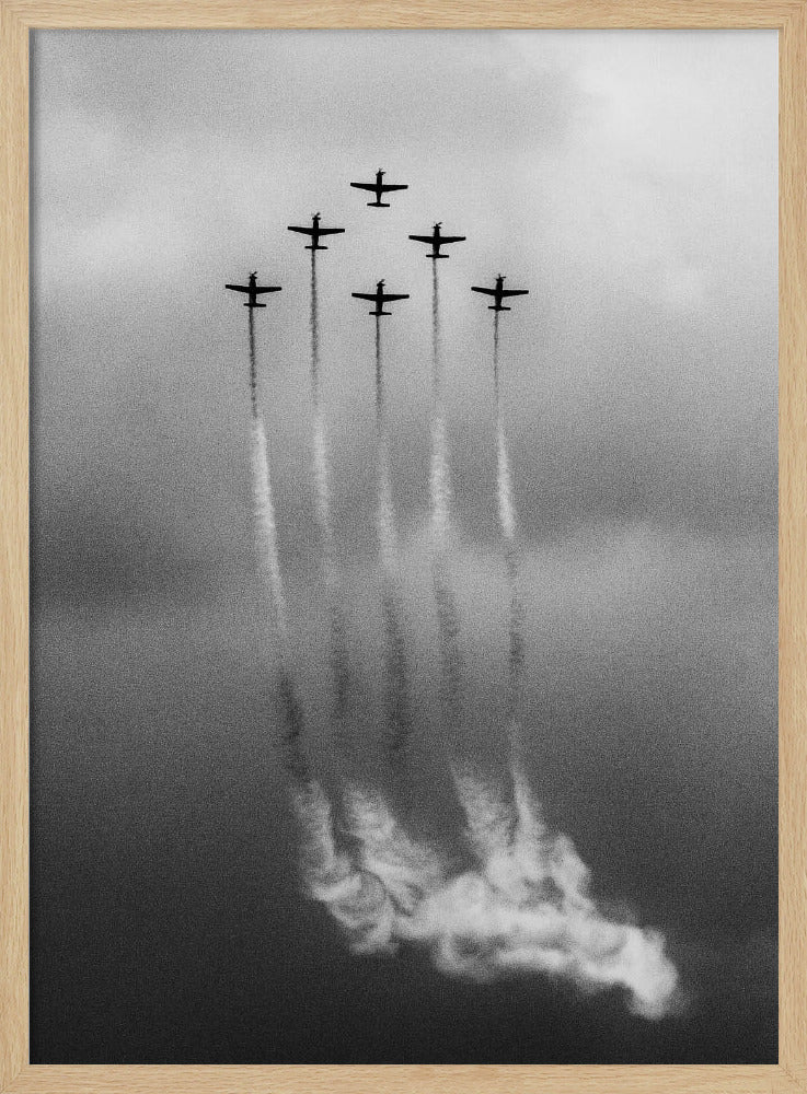 A grainy black and white photo of six airplanes flying in a V-formation against a cloudy sky. Each plane leaves a long, white smoke trail that billows at the bottom of the frame. The image is presented within a black border. Print