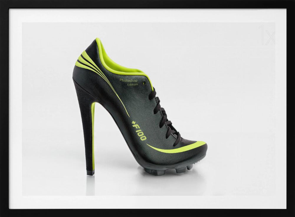 A conceptual piece of digital art featuring a hybrid shoe that is part black soccer cleat and part stiletto high heel. The shoe has neon lime green accents and is displayed against a stark white background inside a silver frame. Decor