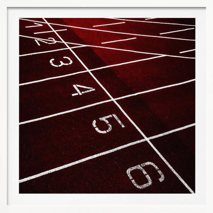 A framed, high-angle photograph of a deep red running track, showing the white lines and numbers for lanes one through six creating a grid-like pattern. Poster