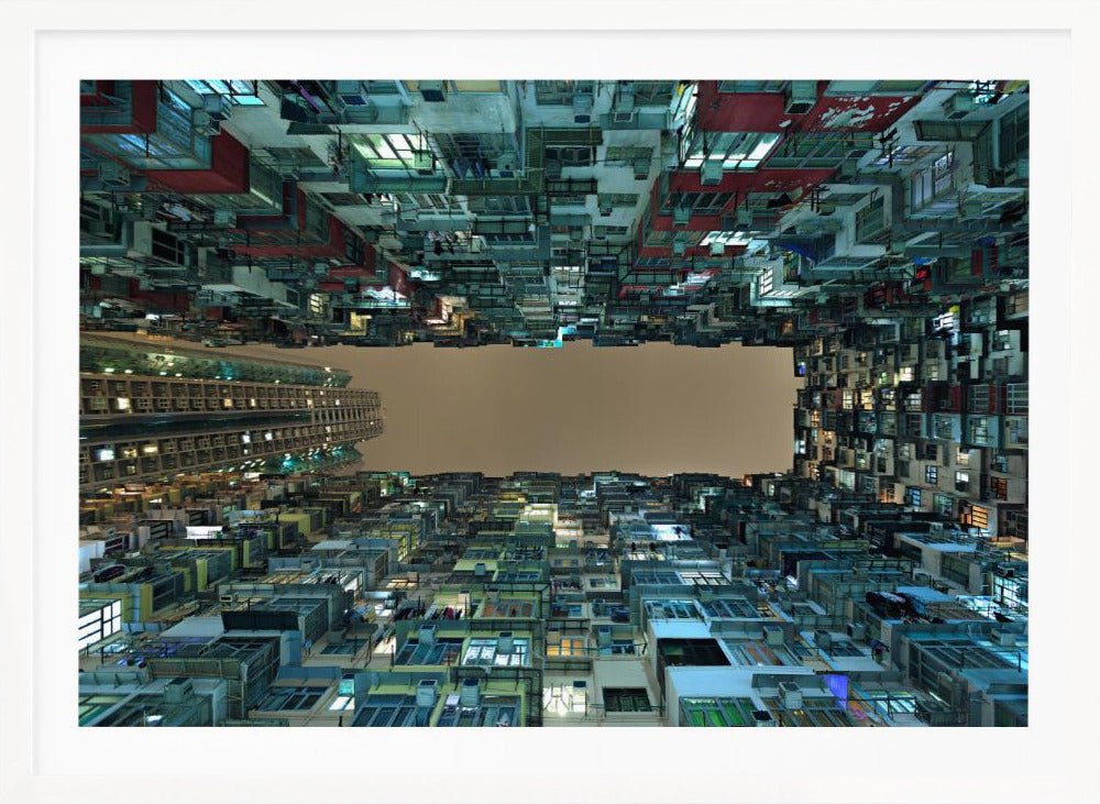 A framed, low-angle photograph looking up from a courtyard at densely packed, colorful apartment buildings that form a rectangle around a blank, overcast sky at night. Print