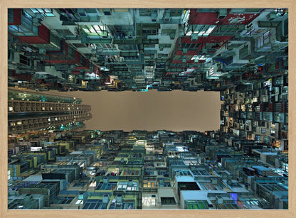 A framed, low-angle photograph looking up from a courtyard at densely packed, colorful apartment buildings that form a rectangle around a blank, overcast sky at night. Print