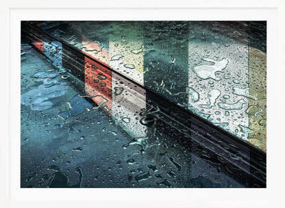An abstract close-up photograph of a wet, dark surface, possibly a car, covered in raindrops, with a prominent black diagonal line. Colorful vertical stripes of red, cream, and green are reflected on the glossy, wet surface. The artwork is presented in a silver frame. Decor