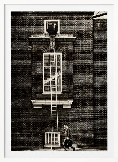 A striking black and white photograph of a man cleaning a small window high up on a brick building, standing precariously at the top of a very long ladder. Below, another man walks past on the street, seemingly unaware of the scene above. Artwork