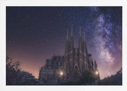 A fantastical night view of the Sagrada Familia in Barcelona, its intricate spires reaching up towards a magnificent, starry sky filled with the purple and pink hues of the Milky Way galaxy, all enclosed in a silver frame. Artwork
