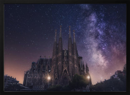 A fantastical night view of the Sagrada Familia in Barcelona, its intricate spires reaching up towards a magnificent, starry sky filled with the purple and pink hues of the Milky Way galaxy, all enclosed in a silver frame. Artwork