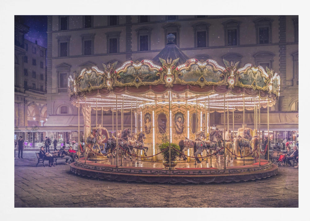 A beautifully illuminated vintage carousel with ornate horses in a European cobblestone plaza at night. The carousel is the central focus, glowing with warm lights against a backdrop of historic buildings and a starry purple sky. Poster