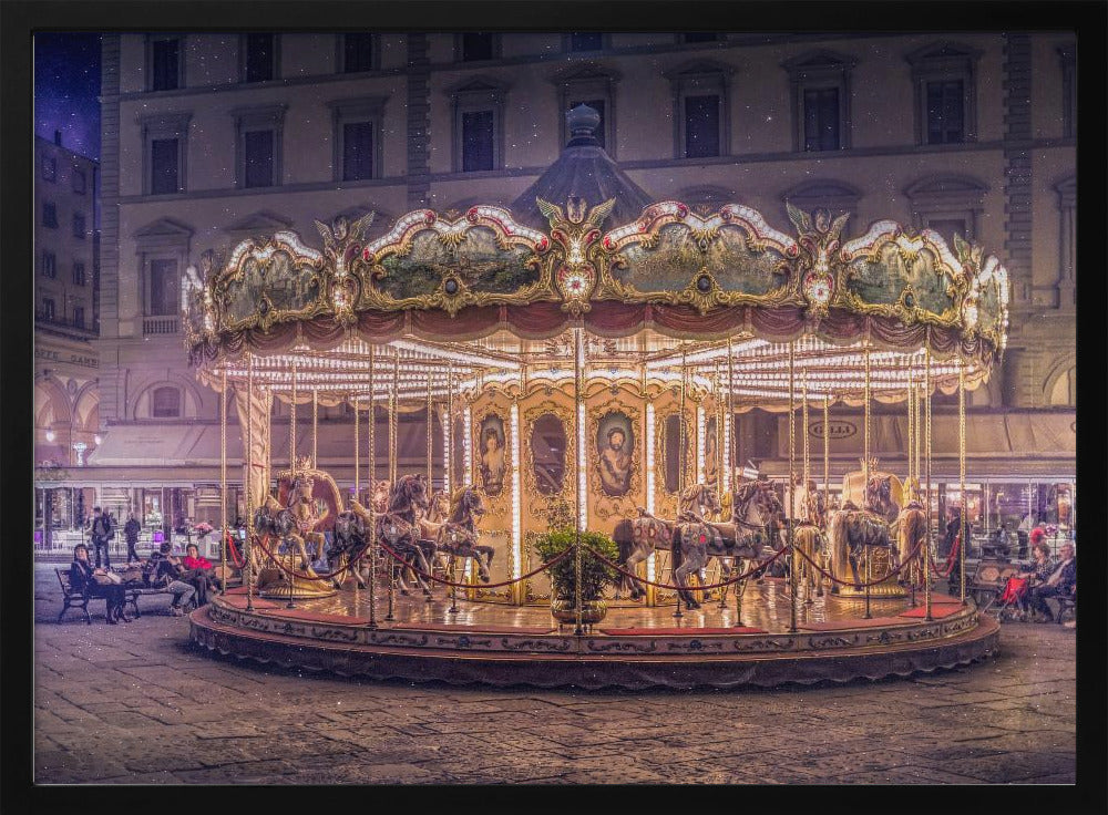 A beautifully illuminated vintage carousel with ornate horses in a European cobblestone plaza at night. The carousel is the central focus, glowing with warm lights against a backdrop of historic buildings and a starry purple sky. Poster