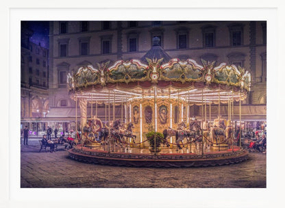A beautifully illuminated vintage carousel with ornate horses in a European cobblestone plaza at night. The carousel is the central focus, glowing with warm lights against a backdrop of historic buildings and a starry purple sky. Poster