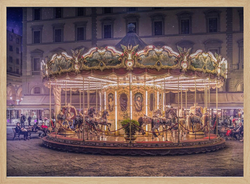 A beautifully illuminated vintage carousel with ornate horses in a European cobblestone plaza at night. The carousel is the central focus, glowing with warm lights against a backdrop of historic buildings and a starry purple sky. Poster