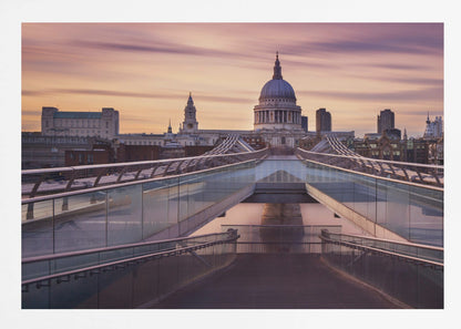A photograph looking down the center of the Millennium Bridge in London, leading the eye directly to St. Paul's Cathedral, which is centered in the background under a beautiful purple and orange sunset sky. Print