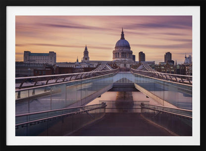 A photograph looking down the center of the Millennium Bridge in London, leading the eye directly to St. Paul's Cathedral, which is centered in the background under a beautiful purple and orange sunset sky. Print