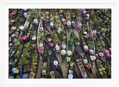 An aerial photograph of a crowded floating market in Southeast Asia, with dozens of narrow wooden boats filled with vibrant green produce and colorful wares on a brown river. Poster